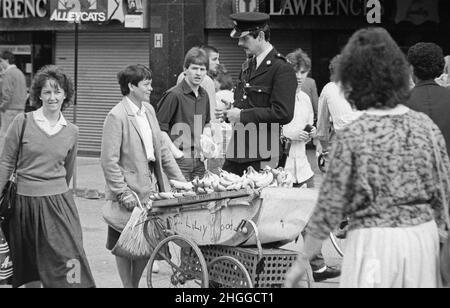 Garda-Offizier im Gespräch mit Straßenhändler, 1985. Oktober, Dublin, Republik Irland Stockfoto