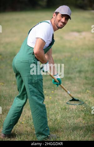 Gärtner mit Rechen bei der Arbeit Stockfoto