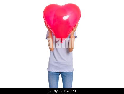 Teen Mädchen versteckt sich hinter roten Herz geformten Ballon. Kind hält Symbol der Liebe, Familie, Hoffnung, Valentinstag. Teenager-Cover Gesicht isoliert auf weiß. Stockfoto