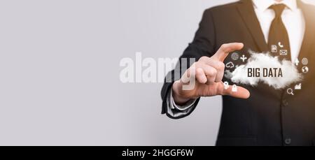 Geschäftsmann hält die Inschrift , Wort BIG DATA . Vorhängeschloss, Gehirn, Mann, Planet, Graph, Lupe, Zahnräder, Symbol für Cloud, Grid, Dokument, Brief, Telefon Stockfoto