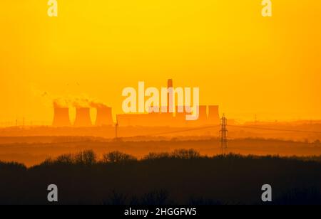 Fernsicht von den Yorkshire Wolds auf die Kühltürme eines Kraftwerken in der Nähe von Drax in North Yorkshire. Die Sonne geht in einer kalten Winternacht unter Stockfoto