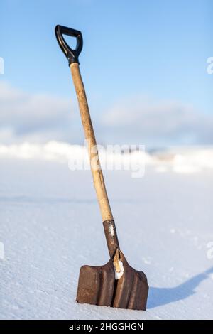 Metallschaufel mit Schnee in Nahaufnahme stecken. Schneeräumung im Winter danach Stockfoto