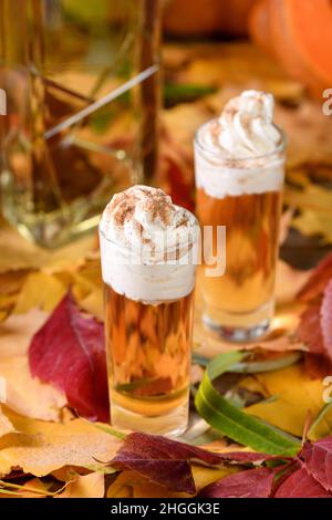 Zwei Wodka mit cremefarbenen Zimt-Kürbis-Pie-Schützen in Schrotgläsern. Diese Getränke sind leicht zu machen und perfekt für den Herbst. Probieren Sie diese alkoholischen Getränke bei Ihnen Stockfoto