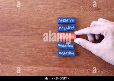 Draufsicht Bild von Hand Pick Holzwürfel mit Text POSITIV über NEGATIV Stockfoto