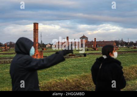 Am 3. Januar 2022 wurde in Oswiecim, Polen, ein Krematoriumskornstein in Ruinen und das Tor des Todes, der Haupteingang des ehemaligen KZ-Vernichtungslagers Auschwitz II-Birkenau, hinterlassen. Stockfoto