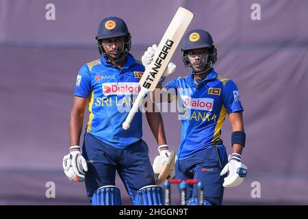 Kandy, Sri Lanka. 21st Januar 2022. Sri Lankas Pathum Nissanka (R) feiert, nachdem er ein halbes Jahrhundert (50 Runs) erzielt hat, als sein Teamkollege Kamindu Mendis (L) am 21st. Januar 2022 beim dritten eintägigen internationalen (ODI) Cricket-Spiel zwischen Sri Lanka und Simbabwe im Pallekele International Cricket Stadium in Kandy zuschaut. Viraj Kothalwala/Alamy Live News Stockfoto