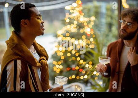 Zwei männliche Freunde feiern mit Wein im Hinterhof Stockfoto