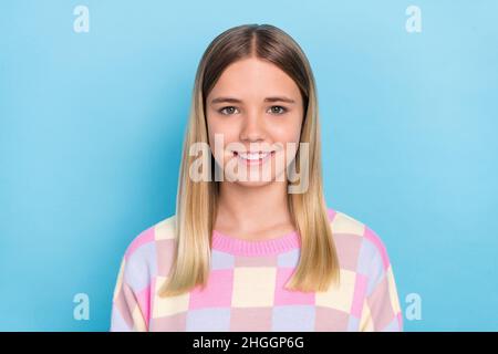 Portrait von attraktiven fröhlich niedlichen Mädchen trägt karierten Pullover isoliert über lebendigen blauen Hintergrund Stockfoto