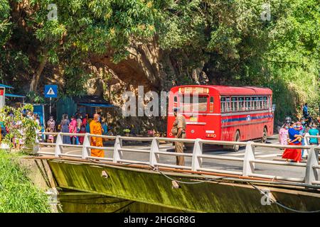 ELLA, SRI LANKA - 27. DEZEMBER 21: Mönch und Polizist an den Ravana Wasserfällen Ella, in der Nähe von Ella Town, Sri Lanka Stockfoto