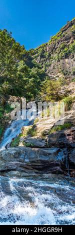 ELLA, SRI LANKA - 27. DEZEMBER 21: Langer Fluss des Ravana-Wasserfalls im Tal vom Berg Ella Rock in der Nähe von Ella, Sri Lanka, vertikal Stockfoto