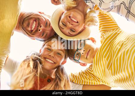 Glückliche Familie mit Tochter und Sohn im Kreis über die Natur im Sommer Stockfoto