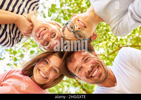 Eltern mit Tochter und Sohn stehen im Sommer im Park Kopf an Kopf auf die Natur Stockfoto
