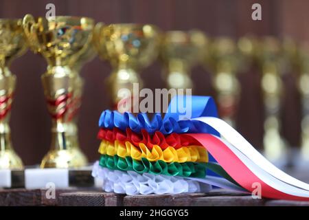 Gruppe von Pferdesport-Trophäen und Abzeichen Rosetten bei Reitsport-Veranstaltung in Reihe. Haufen von Sporttrophäen und Abzeichen Rosetten für die Sieger auf der Ausstellung Stockfoto