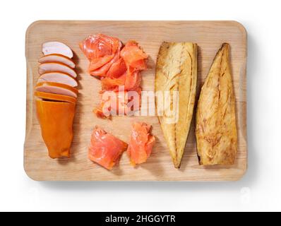 Geräuchertes Huhn, Makrele und Lachs auf einem Schneidekneider in einem Studio-Setting isoliert auf Weiß. Stockfoto
