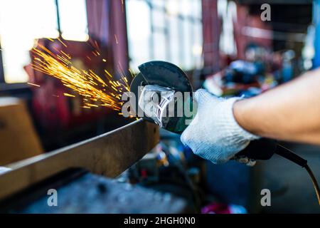 lateinischer hispanischer Automechaniker in Uniform untersucht ein Auto, während er im Autodienst arbeitet Stockfoto