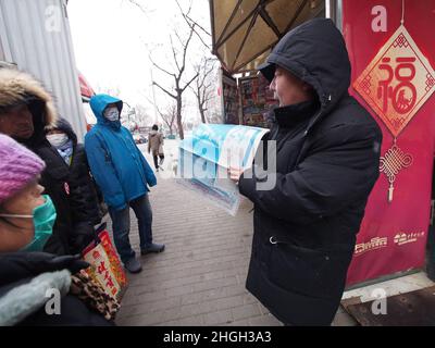 PEKING, CHINA - 212. JANUAR 2022 - an einem Postkioské in Peking, Hauptstadt von China, kaufen Menschen Zeitschriften für die Olympischen Winterspiele, 21. Januar 2022. Der Beamte Stockfoto