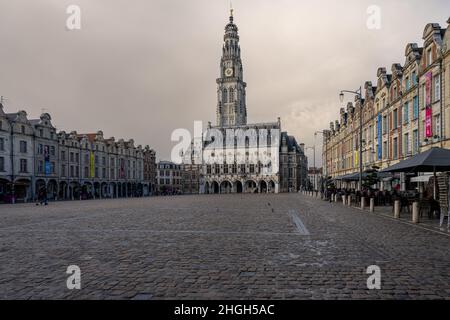 Arras, Frankreich - 4. November 2021: Marktplatz von Arras, Frankreich. Der Belfried von Arras, das zum UNESCO-Weltkulturerbe gehört, steht vor einem dunkelgrauen Himmel Stockfoto