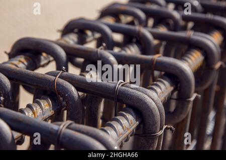 Montage von Bewehrungsstäben zum Ausgießen von Beton. Industrieller Hintergrund. Bewehrungsstruktur Bewehrungsstahl für Stahlbeton auf der Baustelle. Stockfoto