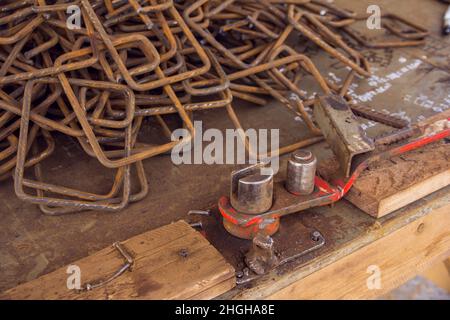 Montage von Bewehrungsstäben zum Ausgießen von Beton. Handwerkzeug zum Biegen von Bewehrungen für Betonarbeiten. Bauwerkzeug für das Biegen von Eisen Stockfoto