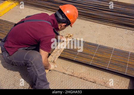 Montage von Bewehrungsstäben zum Ausgießen von Beton. Industrieller Hintergrund. Bewehrungsstruktur Bewehrungsstahl für Stahlbeton auf der Baustelle. Stockfoto