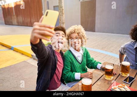 Selfie eines jungen lächelnden multirassischen Paares, das Spaß zusammen hat Stockfoto
