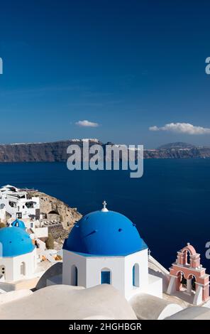 Ein Blick von der Insel Santorini über die Ägäis mit den blauen Kuppelkirchen in Oia. Stockfoto