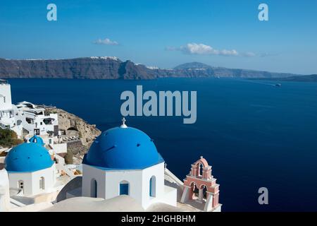 Ein Blick von der Insel Santorini über die Ägäis mit blauen Kuppelkirchen in Oia. Stockfoto