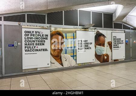 WESTMINSTER, LONDON, GROSSBRITANNIEN. 21st Januar 2022. Schilder an der U-Bahnstation Westminster fordern das Ende der Coronavirus-Pandemie durch die Förderung von Impfungen für die Welt. Kredit: amer ghazzal/Alamy Live Nachrichten Stockfoto