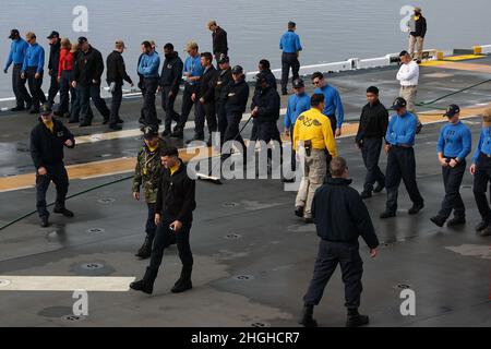 220118-N-OP825-1060 PAZIFISCHER OZEAN (JAN 18, 2022) Matrosen nehmen an einem Foreign Object Debris (FOD) Teil, der an Bord des amphibischen Angriffsschiffs USS Tripoli (LHA 7) auf dem Flugdeck läuft, Januar 18. Tripoli ist ein Amphibienschiff der amerikanischen Klasse, das in San Diego homeportiert wurde. Stockfoto