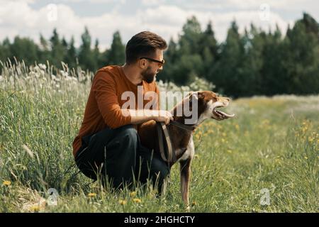Mann und glücklicher Hund schauen weg in ländlichen. Stockfoto