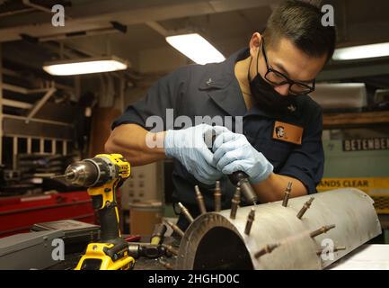 PHILIPPINISCHES MEER (Jan 19, 2022) Aviation Structural Mechanic 3rd Class Yangliu Lin, aus Flagstaff, Arizona, nietet einen Mast an Bord der USS Abraham Lincoln (CVN 72). Abraham Lincoln, der als Teil der US-Pazifikflotte tätig ist, führt Schulungen durch, um eine freie und offene Region im Indo-Pazifik-Raum zu erhalten und zu schützen. Stockfoto