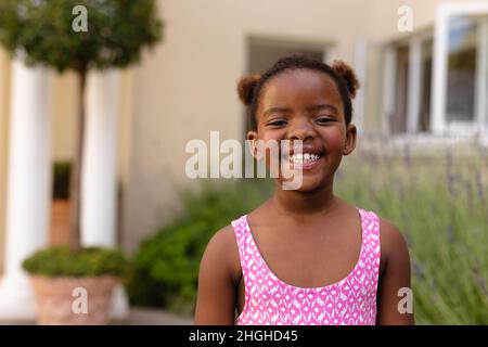 Porträt von glücklich niedlichen afroamerikanischen Mädchen trägt rosa ärmellose Top Stockfoto