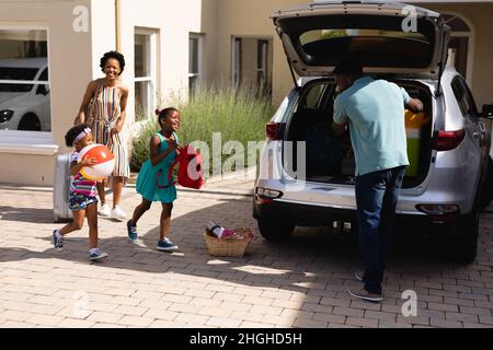 Der afroamerikanische Vater legte das ganze Gepäck in die Rückseite des Autos Stockfoto