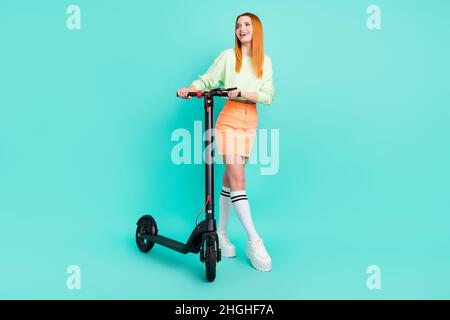 In voller Länge Foto von charmanten glücklich verträumt Frau suchen leeren Raum halten Roller auf blauem Hintergrund isoliert Stockfoto