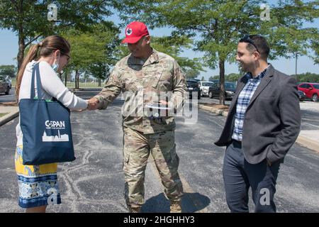 Oberst Michael A. Hrynciw, Kommandant des roten PFERDES mit zwei Zähnen, übergibt Margaret McInnis, Repräsentantin des Kongressabgeordneten des Ohio District 9, Marcy Kapturs Mitarbeiterin für Verteidigung, Veteranen und MILCON-VA-Mittel, eine Münze, nachdem sie am 4. August 2021 das 200. SQUADRON DES ROTEN PFERDES in Camp Perry, Port Clinton, Ohio, besucht hatte. RED HORSE Leadership und zwei Gäste des Kongresses diskutierten den Plan VON RED HORSE, mehrere Gebäude durch eine effizientere Mehrzweckanlage zu ersetzen. Stockfoto