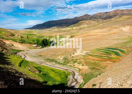 Das Atlasgebirge in Marokko. Die Ufer des wadi sind fruchtbar, während die Berge sehr fruchtbar sind Stockfoto