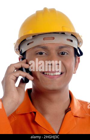 Mumbai; Maharashtra; Indien- Asien; 26. Dezember; 2009 - glücklicher, gut aussehender junger Mann aus indien, der Uniform und Helm trägt; im Gespräch mit dem Mobiltelefon. Stockfoto
