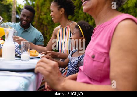 Lächelnde afroamerikanische Familie genießt Brunch im Garten Stockfoto