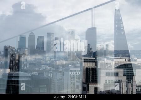 Aus einer erhöhten Perspektive betrachtet, die die Reflexionen der beiläufigen Architektur einschließlich des Shard umfasst, ein Blick über die City of London, das Finanzviertel der Hauptstadt (auch bekannt als The Square Mile), in Richtung London Docklands, am 20th. Januar 2022, in London, England. Stockfoto