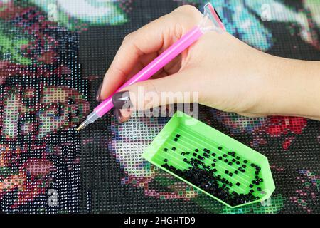 Frau sammelt Diamantmalerei oder Diamantmosaik aus der Nähe Stockfoto