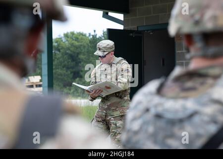 Personal Sgt. Arlo Wenter, ein Infanterist der 78. Trainingsdivision, liest vor dem Konvoi-Training während der Combat Support Training Exercise (CSTX) in Fort McCoy, Wisconsin, am 9. August 2021, einen Sicherheitsbrief vor Soldaten der US-Army Reserve. Diese Schulung umfasst die Reaktion auf indirekte Brände und die Durchführung von Kampflebensretter-Fähigkeiten. CSTX wird verwendet, um Schulungskenntnisse zu erlangen, die es Reserve-Einheiten ermöglichen, die kollektive Bereitschaft vor der Mobilisierung zu verbessern. Stockfoto