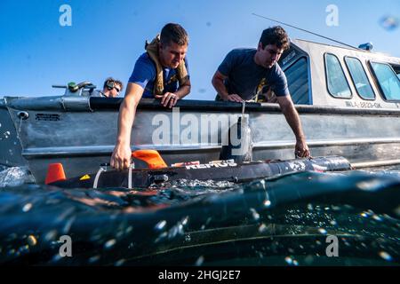 Navy Diver 2. Klasse Chris Costa und Navy Diver 2. Klasse Brandon Barreto, beide zugeordnet zu Mobile Diving Salvage Unit (MDSU) 2, setzen ein MK-18 Mod 1 unbemannten Unterwasser-Fahrzeug Stockfoto