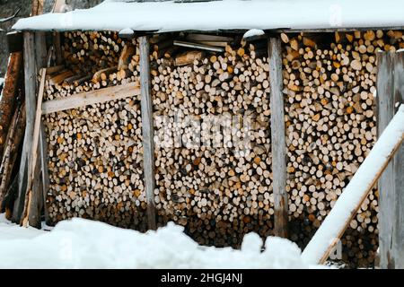 Holzschuppen mit Schnittholz im Winter Stockfoto