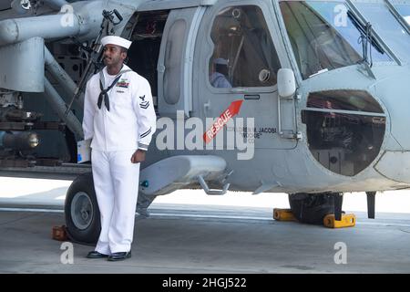 210812-N-EV253-1251 SAN DIEGO (AUG 12, 2021) – Aviation Structural Mechanic 2nd Class Melshi Miclisse, zugeordnet zu den „Merlins“ des Helicopter Sea Combat Squadron (HSC) 3, Und aus Miami, Florida, steht auf der aufmerksam, nachdem sie während einer Befehlswechselzeremonie auf der Naval Air Station (NAS) North Island in Coronado, Kalifornien, am 12. August die Bezeichnung „Erdrutsch 00“, das Ausstellungsflugzeug des Geschwaders, geändert hat. Während der Zeremonie, Cmdr. Loren Jacobi entlasten Capt. William Eastham als kommandierenden Offizier von HSC-3. HSC-3 ist die West Coast MH-60S Flottenersatzstaffel der Marine, verantwortlich für die Ausbildung von Piloten und Stockfoto