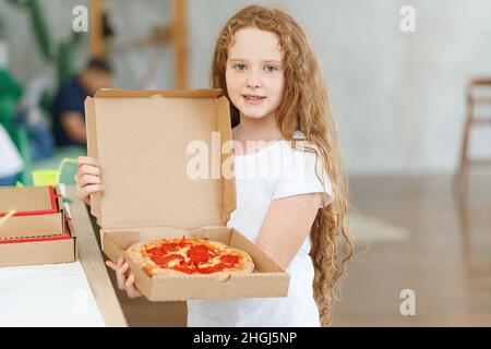 Happy Little girl Holding box mit Pepperoni Pizza. Stockfoto