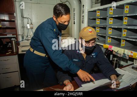 210813-N-DH793-1095 ATLANTIK (AUG 13, 2021) Senior Chief Yeoman Tracy Davis, links, aus Greenwood, Mississippi, gibt an Bord des Nimitz-Klasse-Flugzeugträgers USS Harry S. Truman (CVN 75) Hilfestellung bei der Weiterleitung von Verwaltungsdokumenten an Yeoman 2nd Class Nikola Karaulic aus Dacula, Georgia. Truman führt im Atlantischen Ozean Bereitschaftstrainings durch, um sich auf den zukünftigen Betrieb vorzubereiten. Stockfoto