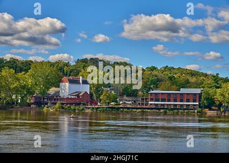 Blick in Richtung Bucks County Playhouse in New Hope Pennsylvania von Lambertville NJ übernommen über den Delaware River. Mit einem Einzelboot, das stromaufwärts rudert. Stockfoto