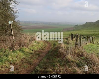 Öffentlicher Fußweg und Steg, der am Maiden Castle in der Nähe von Dorchester, Dorset, vorbeiführt Stockfoto