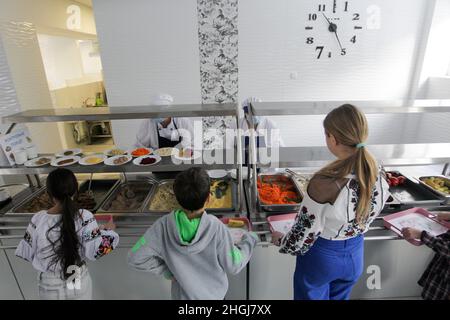 KIEW, UKRAINE - 21. JANUAR 2022 - die Schüler wählen die Gerichte in der Kantine der Suziria-Schule N209, Kiew, Hauptstadt der Ukraine. Schulen sind jetzt introdu Stockfoto