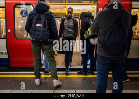 London, Großbritannien. 21. Januar 2021. Ein Mann, der keine obligatorische Gesichtsbedeckung trägt, verlässt einen U-Bahn-Wagen in der Baker Street. Die britische Regierung hat vor kurzem die Lockerung der Beschränkungen angekündigt, die zur Bekämpfung der Omicron-Variante eingeführt wurden, wie das obligatorische Tragen von Masken in öffentlichen Verkehrsmitteln und in Geschäften, Anleitung zur Arbeit von zu Hause aus und Impfstoffzertifikate. Der Bürgermeister von London hat jedoch gesagt, dass Gesichtsbedeckungen immer noch eine Bedingung für den Transport von Londoner Netzen (TFL) sein werden. Kredit: Stephen Chung / Alamy Live Nachrichten Stockfoto